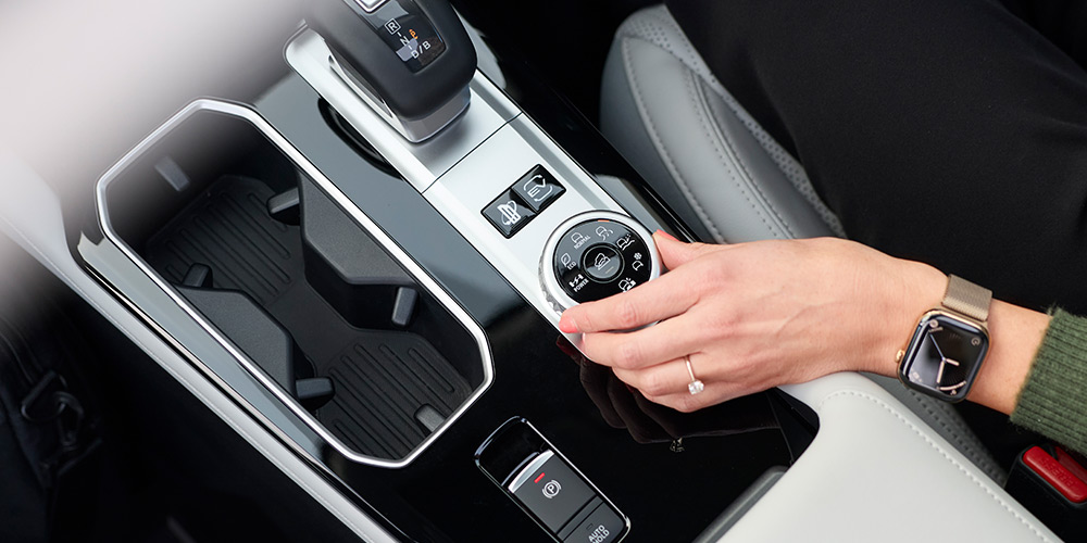 A womans hand on a drive-mode change dial