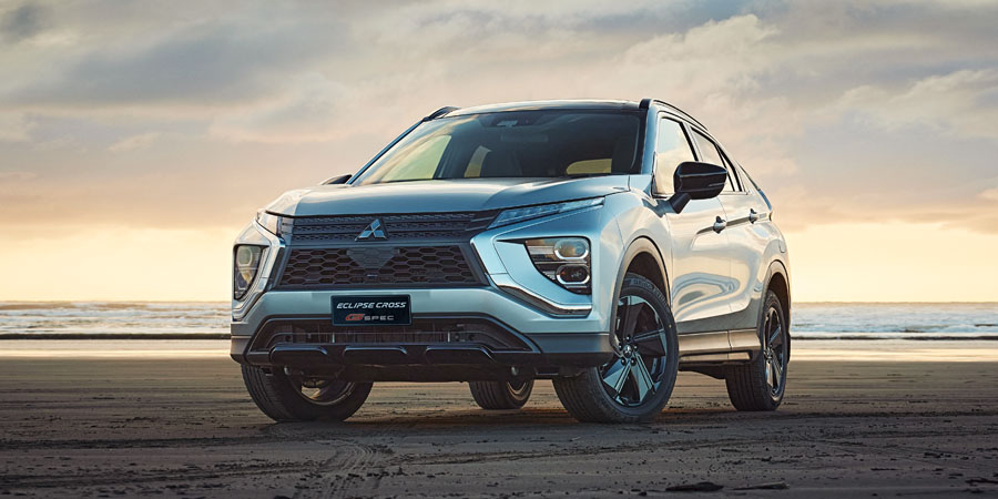 Grey SUV on a beach at sunset