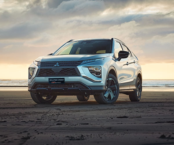 Grey SUV on a beach at sunset