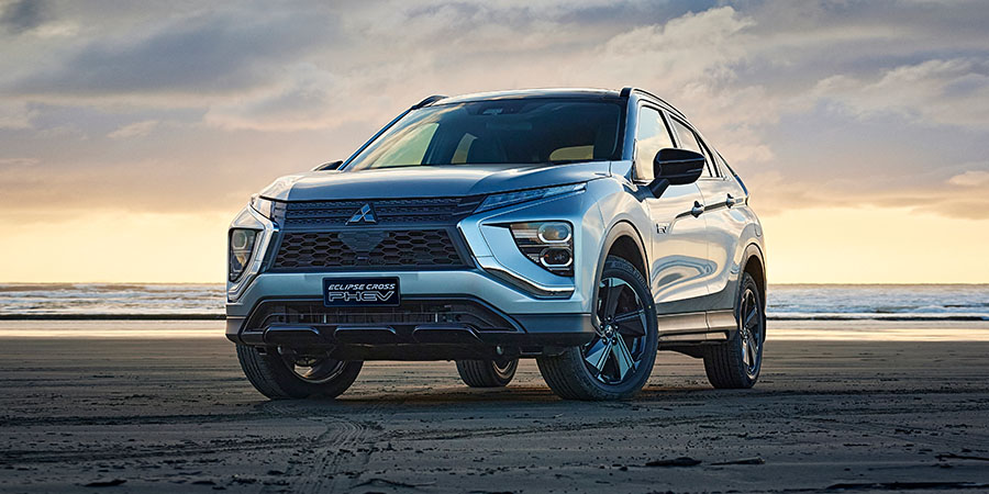 Grey SUV on a beach at sunset