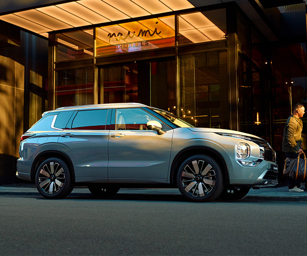 A Grey Mitsubishi SUV parked outside a hotel
