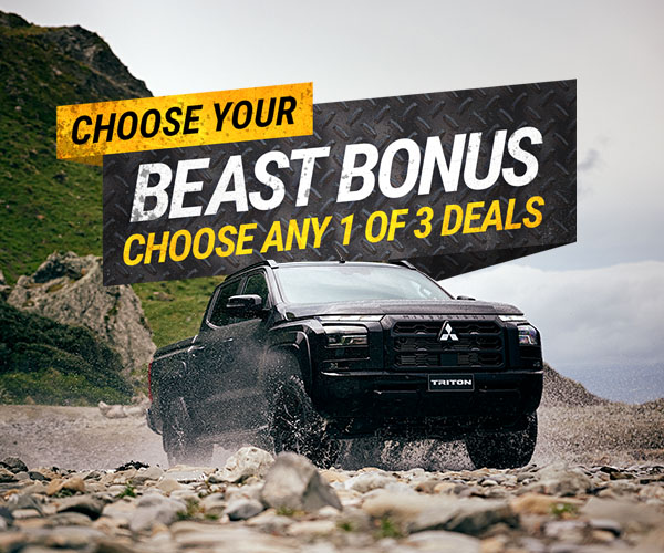 A black triton ute with beast pack graphics behind it